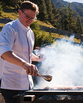 Chef grilling outdoors at the Posthotel Achenkirch, gourmet cuisine in Tyrol