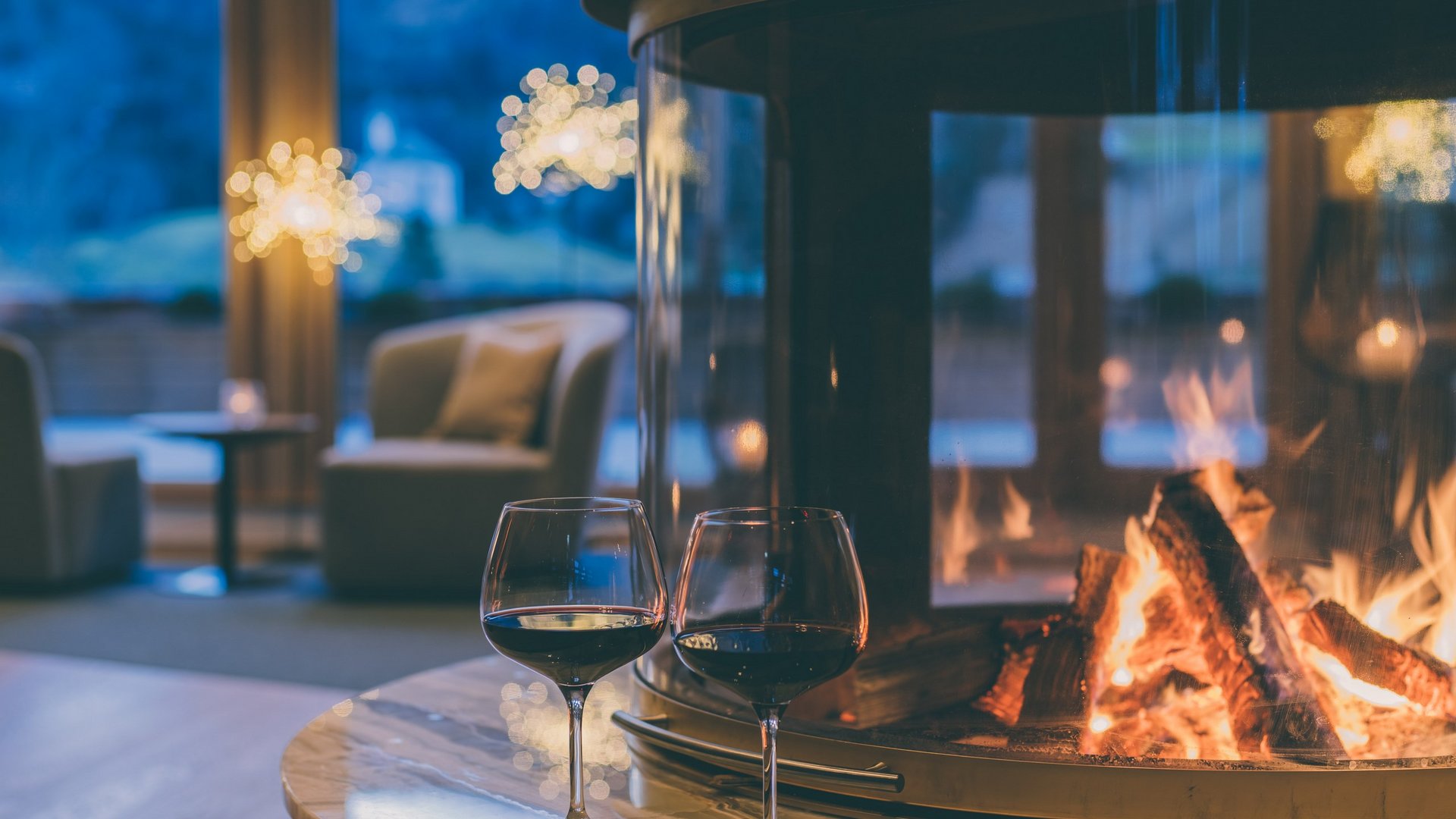 Posthotel Achenkirch Zwei Weingläser vor einem Kamin im 5 Sterne Hotel Tirol